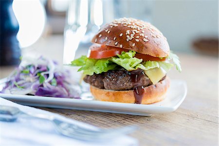 simsearch:659-08940660,k - A hamburger with cheese, lettuce and tomato served with coleslaw Stock Photo - Premium Royalty-Free, Code: 659-08420149