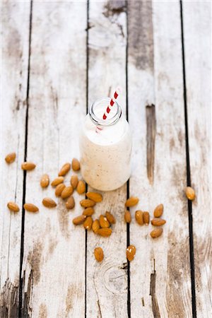 simsearch:659-08895731,k - A bottle of almond milk and almond on a wooden surface Photographie de stock - Premium Libres de Droits, Code: 659-08420154