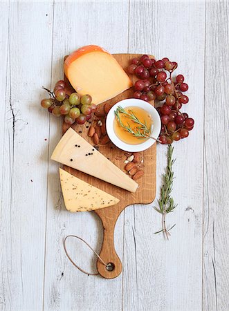 A cheeseboard with grapes, almond olive oil and rosemary Stock Photo - Premium Royalty-Free, Code: 659-08420242