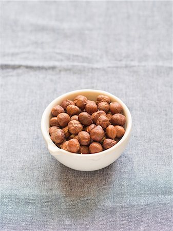 simsearch:659-07959102,k - Hazelnuts in a small ceramic mortar on a lisght blue tablecloth. Stock Photo - Premium Royalty-Free, Code: 659-08420346