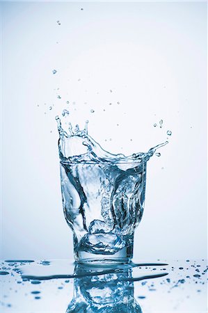 splashing drink in glass - Water splashing out of a glass Stock Photo - Premium Royalty-Free, Code: 659-08513009