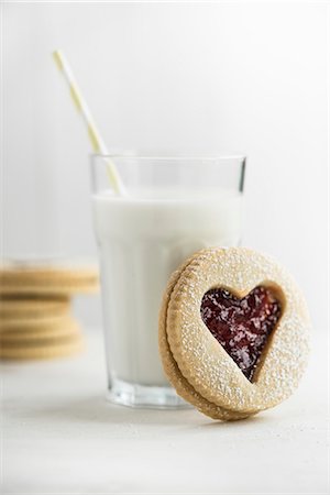 A heart-shaped jam sandwich biscuits in front of a glass of milk Photographie de stock - Premium Libres de Droits, Code: 659-08513035