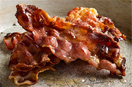 fried sausage recipe - A stack of crispy rashers of bacon in a pan Stock Photo - Premium Royalty-Free, Code: 659-08513055