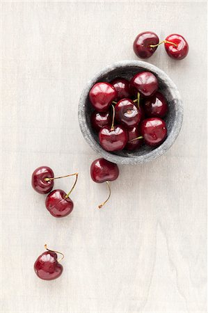Fresh cherries in a marbled bowl and next to it Stock Photo - Premium Royalty-Free, Code: 659-08513050