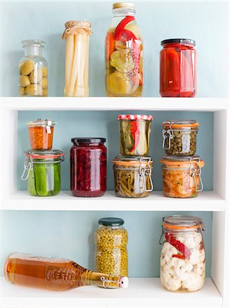 Various jars of vegetables on a shelf with a bottle of home-brewed beer Foto de stock - Sin royalties Premium, Código: 659-08513067