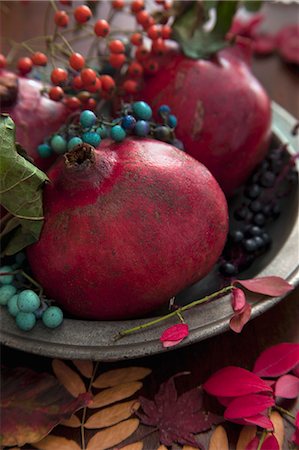 dekoration - Pomegranates with autumnal sprigs of berries on a pewter plate Stockbilder - Premium RF Lizenzfrei, Bildnummer: 659-08513073