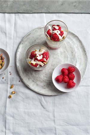 soft fruit dish - Yogurt with fresh raspberries, pistachios and coconut flakes Stock Photo - Premium Royalty-Free, Code: 659-08513132