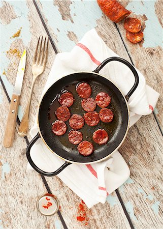 Fried chorizo slices in a pan Photographie de stock - Premium Libres de Droits, Code: 659-08513188