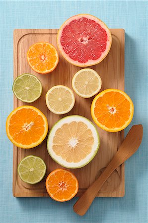 Halved citrus fruits on a wooden board Stock Photo - Premium Royalty-Free, Code: 659-08513273