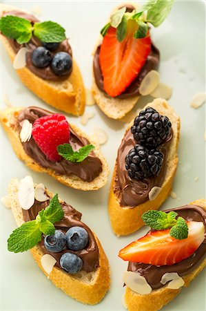 simsearch:659-06151490,k - Baguette slices topped with nougat cream and berries as snacks for children Foto de stock - Sin royalties Premium, Código: 659-08513293