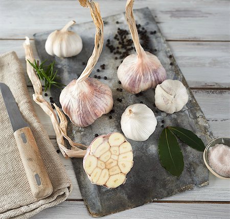 Garlic (purple and white) and bay leaves on a wooden board Photographie de stock - Premium Libres de Droits, Code: 659-08513305