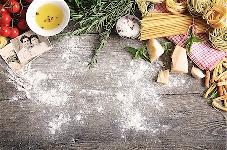 An arrangement of typical Italian food items and family photos on a wooden table Photographie de stock - Premium Libres de Droits, Code: 659-08895329