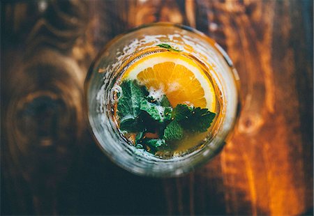 A cocktail garnished with a slice of orange and mint Stock Photo - Premium Royalty-Free, Code: 659-08895374
