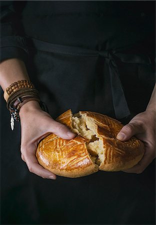 Homemade traditional armenian sweet cake gata in female hands over black background Fotografie stock - Premium Royalty-Free, Codice: 659-08895553