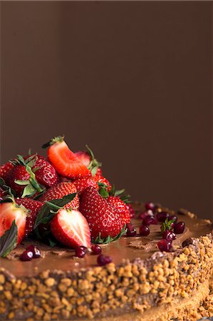 simsearch:659-08897220,k - A chocolate cake topped with strawberries, pomegranate seeds and nuts Stock Photo - Premium Royalty-Free, Code: 659-08895826