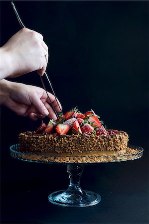 decorated chocolate gateau - A chocolate cake topped with strawberries, pomegranate seeds and nuts Stock Photo - Premium Royalty-Free, Code: 659-08895828