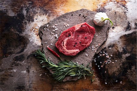 A beef steak, salt, garlic, a chilli pepper and herbs Stockbilder - Premium RF Lizenzfrei, Bildnummer: 659-08895840