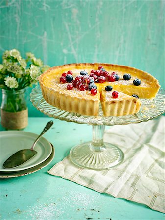 simsearch:659-06306734,k - Lemon tart topped with berries with a slice taken out Fotografie stock - Premium Royalty-Free, Codice: 659-08895986