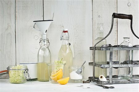 simsearch:659-08896093,k - Homemade elderflower cordial in bottles, fresh elderflowers, lemon halves, sugar, a funnel and small bottle labels Foto de stock - Sin royalties Premium, Código: 659-08896092