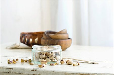 simsearch:659-06187615,k - Pistachios in and next to a glass jar on a rustic kitchen table Photographie de stock - Premium Libres de Droits, Code: 659-08896105