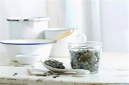 Pumpkin seeds in a glass jar and on a spoon on a rustic kitchen table Foto de stock - Sin royalties Premium, Código: 659-08896107
