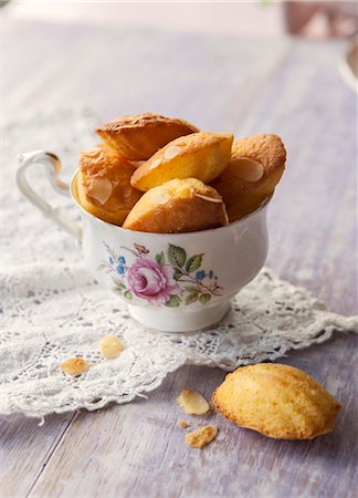 simsearch:659-09125287,k - A vintage tea cup full of madeleines on a lace doily Stock Photo - Premium Royalty-Free, Code: 659-08896149