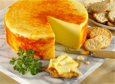 Applewood English cheese round on a marble board with crackers and a herb garnish Photographie de stock - Premium Libres de Droits, Code: 659-08896687