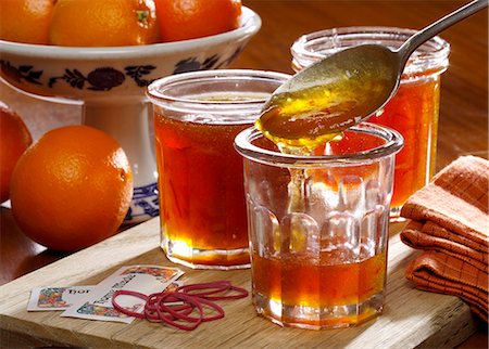 simsearch:659-06306273,k - Homemade marmalade being put into jars with whole oranges in the background Stock Photo - Premium Royalty-Free, Code: 659-08896688