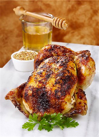placa de mármol - A whole roasted chicken with a honey and mustand glaze showing a dish of mustard and a honey jar and honey drizzler Foto de stock - Sin royalties Premium, Código: 659-08896690