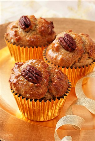 simsearch:659-08147554,k - Several Pecan and Maple (syrup) muffins in gold muffin cases on a gold plate with a gold ribbon Stock Photo - Premium Royalty-Free, Code: 659-08896732