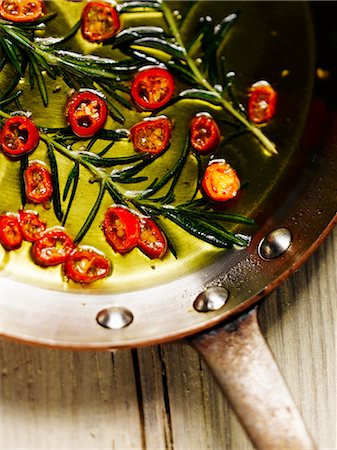 simsearch:659-08940518,k - Chilli rings and rosemary in a pan with olive oil Photographie de stock - Premium Libres de Droits, Code: 659-08897056