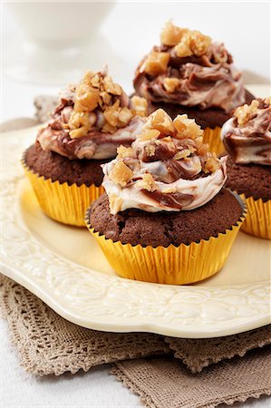 soft cheese cream - Several Peanut butter and chocolate cupcakes with chocolate and cream cheese topping and peanut brittle chips Stock Photo - Premium Royalty-Free, Code: 659-08897069