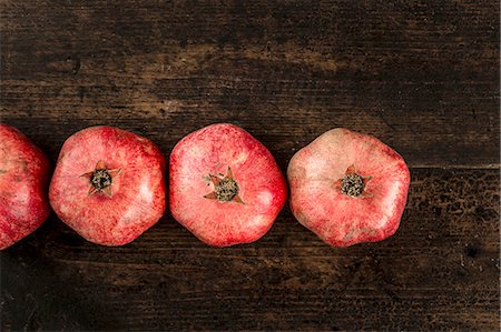 simsearch:659-09124863,k - Row of pomegranates on a wooden surface Photographie de stock - Premium Libres de Droits, Code: 659-08897076