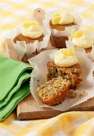 simsearch:659-06151490,k - Several Seeded Lemon drizzle cupcakes in white paper cupcake cases on a wooden board Foto de stock - Sin royalties Premium, Código: 659-08897070