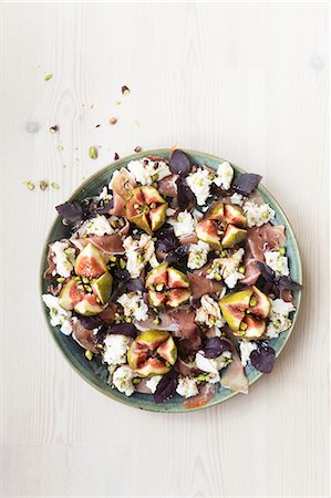 simsearch:649-09206689,k - Fig prosciutto and mozarella salad with purple basil and balsamic vinegar pistachio nuts Photographie de stock - Premium Libres de Droits, Code: 659-08897289