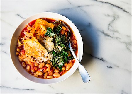 simsearch:659-08939938,k - Cannelleni beans with pasta pieces in a tomato based soup topping with kale and cheese Foto de stock - Sin royalties Premium, Código: 659-08897329