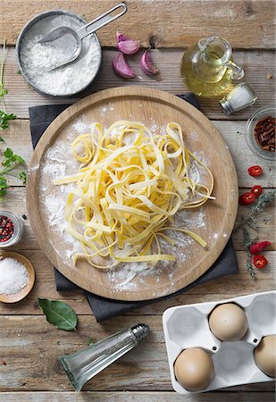 Fresh uncooked tagliatelle on a wooden plate Photographie de stock - Premium Libres de Droits, Code: 659-08904450