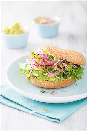 A bagel with cucumber, avocado, radish sprouts and radishes Photographie de stock - Premium Libres de Droits, Code: 659-08904535