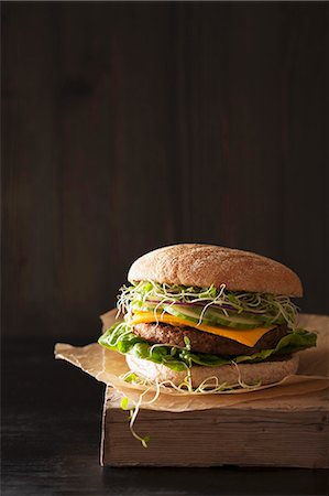 simsearch:659-03535938,k - A vegan burger with a soya patty, vegan cheese, cucumber and clover sprouts Fotografie stock - Premium Royalty-Free, Codice: 659-08904532