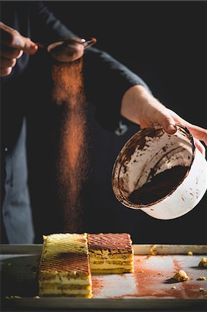 simsearch:659-06495090,k - Tiramisu slices being dusted with cocoa Stock Photo - Premium Royalty-Free, Code: 659-08904604