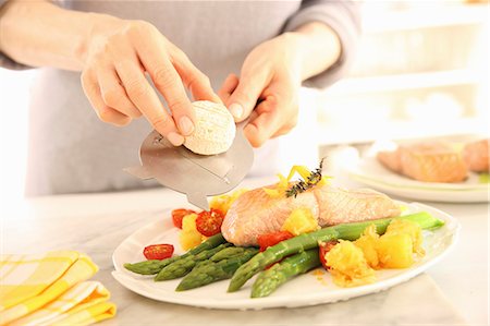 person slicing cheese - Salmon fillet confit with green asparagus, crispy diced potatoes and goat's cheese Stock Photo - Premium Royalty-Free, Code: 659-08904658