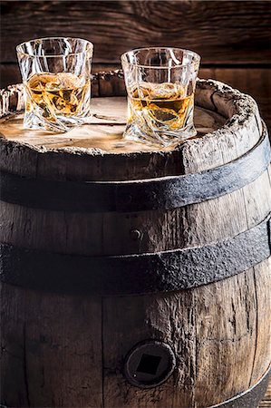 Two glasses of whisky with ice on an old wooden barrel Stock Photo - Premium Royalty-Free, Code: 659-08904764