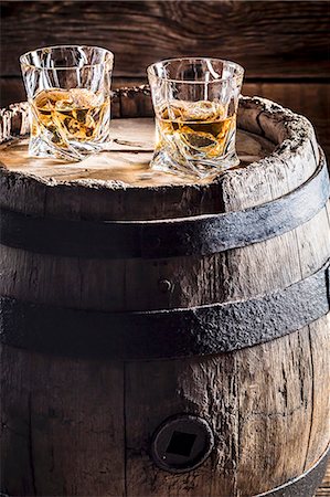 scotch - Two glasses of whisky with ice on an old wooden barrel Stock Photo - Premium Royalty-Free, Code: 659-08904764