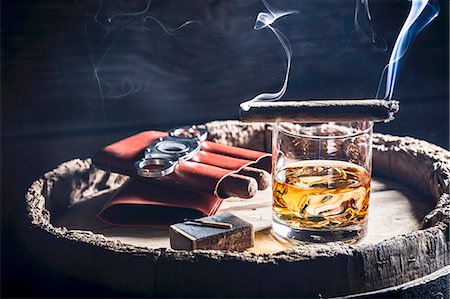 A smoking cigar over a glass of whiskey Stock Photo - Premium Royalty-Free, Code: 659-08904766