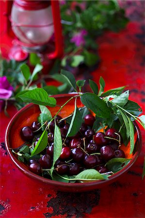 simsearch:659-08904916,k - Fresh cherries with leaves on a red plate Foto de stock - Sin royalties Premium, Código: 659-08904915