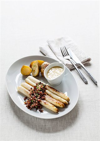 White asparagus with fried diced bacon, chives, Hollandaise sauce and potatoes Stock Photo - Premium Royalty-Free, Code: 659-08905024