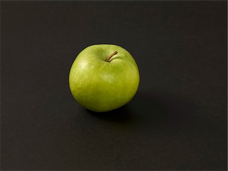 simsearch:659-07027264,k - A green apple on a black surface Photographie de stock - Premium Libres de Droits, Code: 659-08905156
