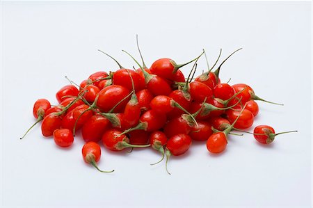 A pile of fresh goji berries on a white surface Foto de stock - Sin royalties Premium, Código: 659-08905248