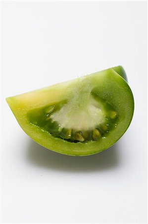 simsearch:659-01854321,k - A wedge of green tomato on a white surface Foto de stock - Royalty Free Premium, Número: 659-08905253