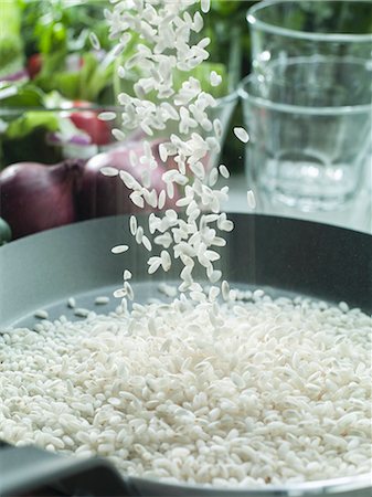 Risotto rice being sprinkled into a pan Stock Photo - Premium Royalty-Free, Code: 659-08905297